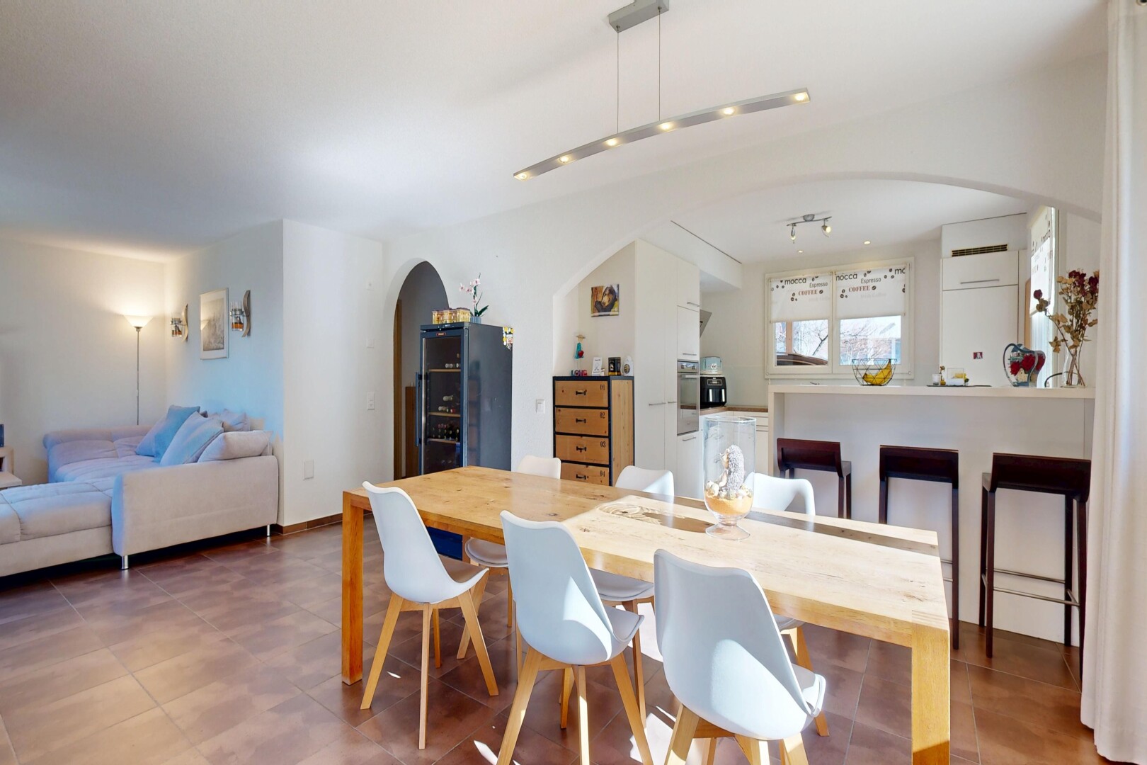 wohn- / esszimmer mit inside property, gipskartonwand, drywall, gewölbte gehwege, und full kitchen