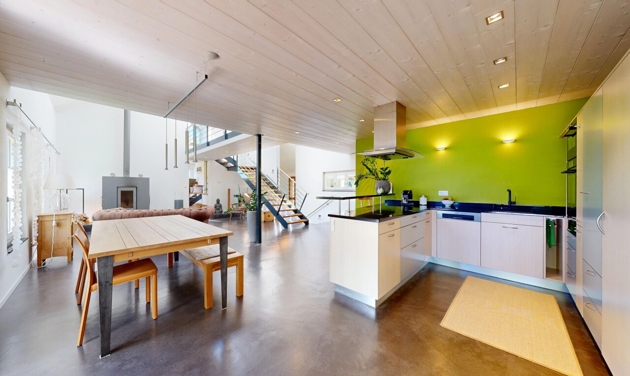 küche mit finished concrete floor, öffnet sich zum wohnraum, opens to living area, arbeitsplatten, und dark countertops