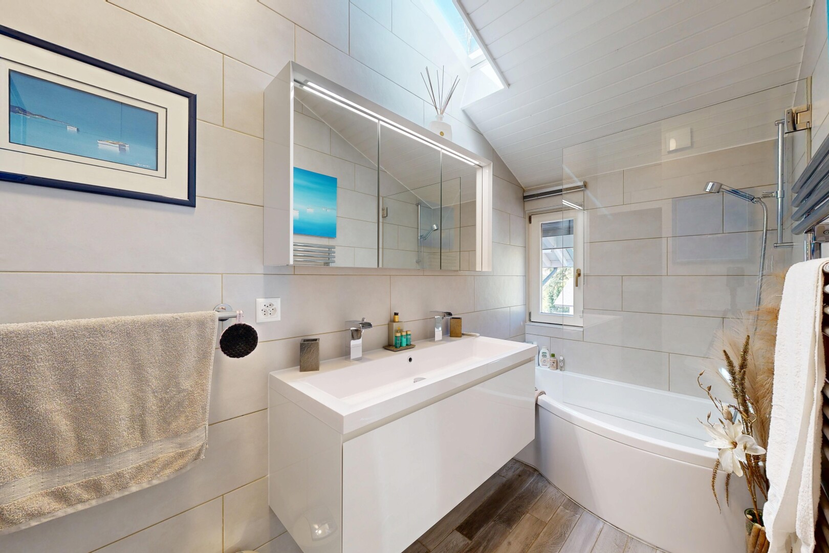 bathroom featuring tile walls, vanity,  shower combination, wood finished floors, and lofted ceiling