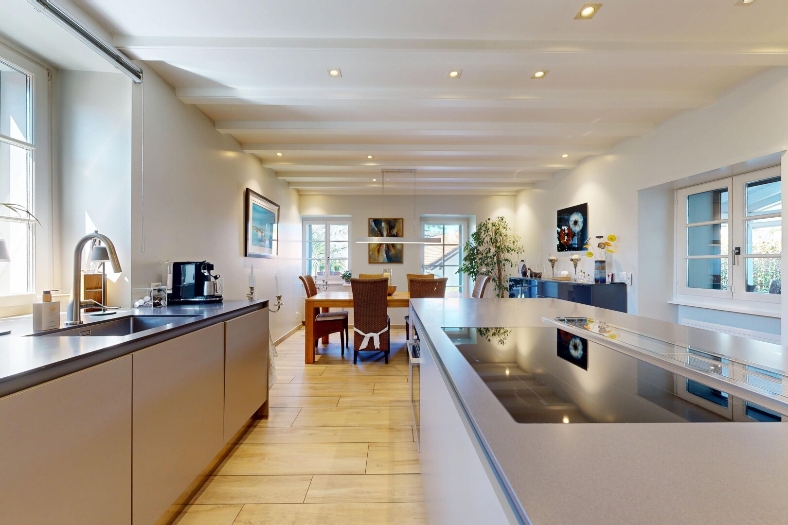 kitchen with light wood-style floors, black electric stovetop, and decorative light fixtures
