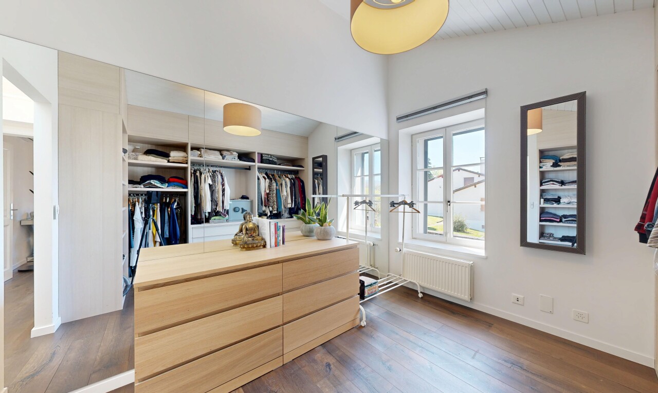 walk in closet with dark wood finished floors, radiator heating unit, and lofted ceiling