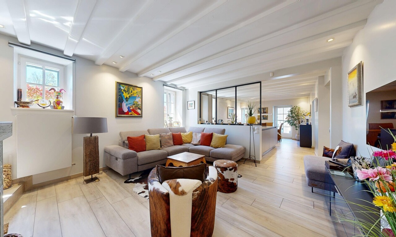 living area with light wood finished floors, healthy amount of natural light, and beam ceiling