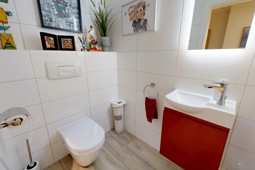 salle de bains avec lavabo (ou coiffeuse selon le contexte), mur en carrelage, tile wall, miroir, et toilette