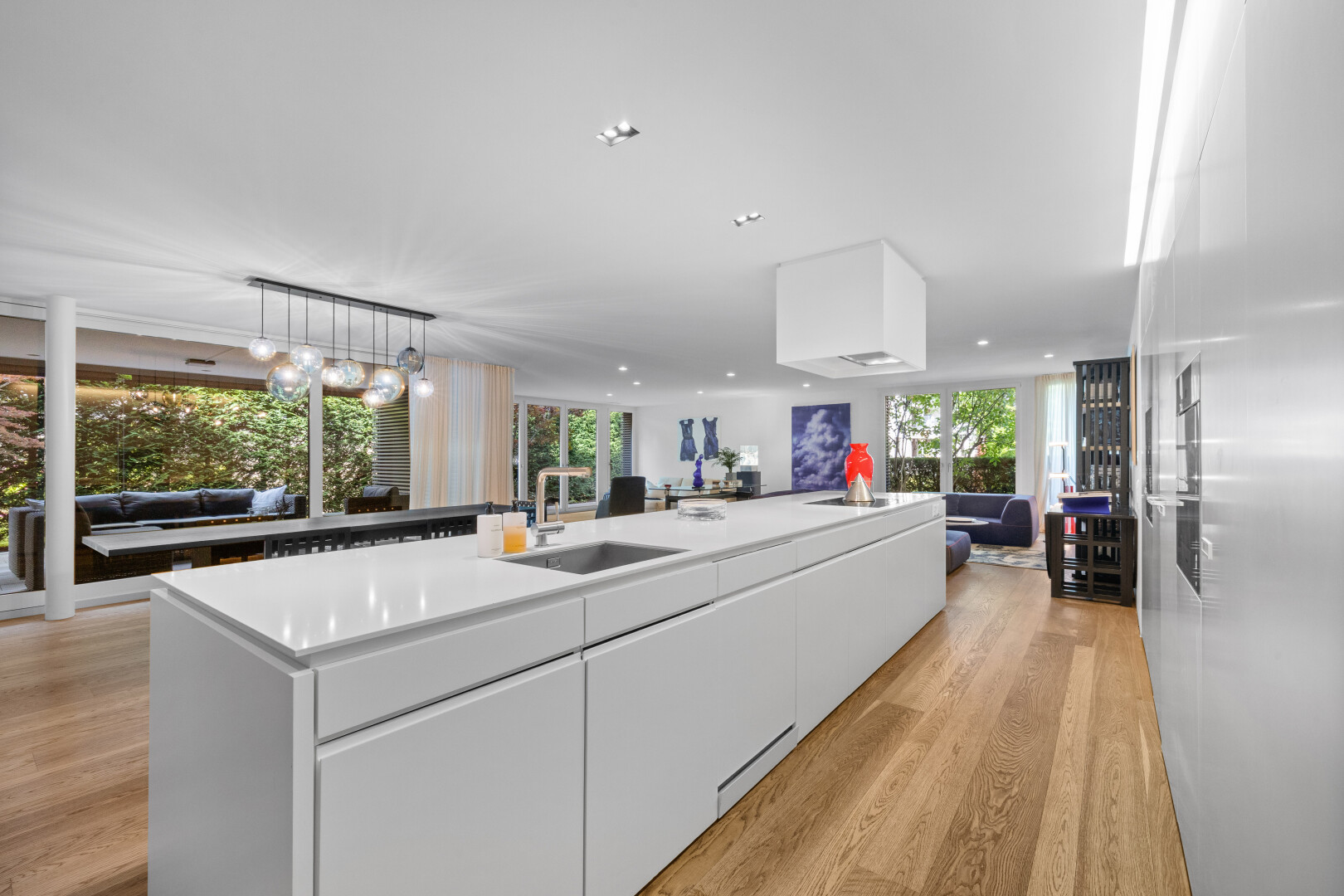 kitchen featuring open floor plan, modern cabinets, a kitchen island with sink, white cabinets, and healthy amount of natural light