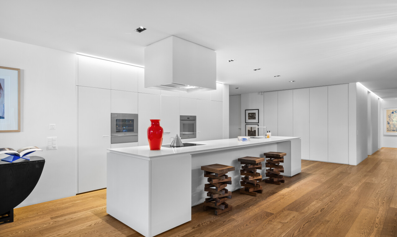 kitchen with modern cabinets, a large island with sink, light wood finished floors, white cabinets, and stainless steel oven