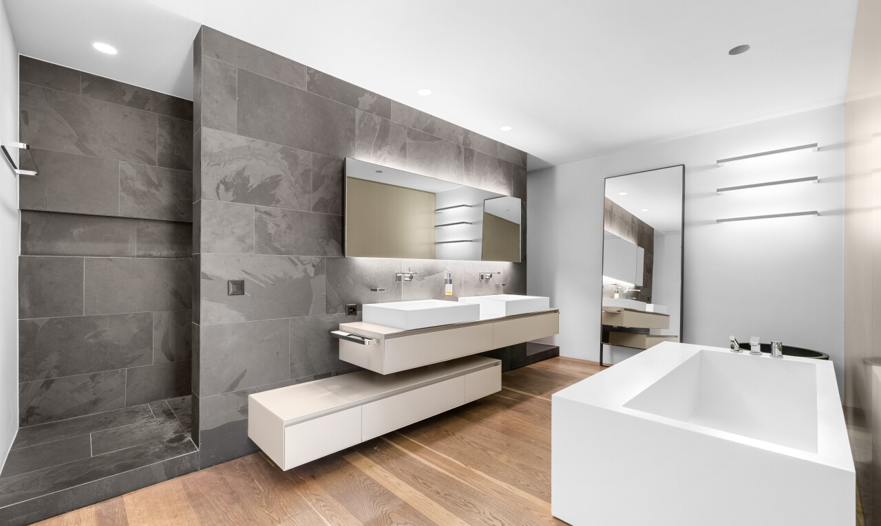 salle de bains avec double vasque, miroir, salle de bain complète, sol en finition bois, et wood finish floor