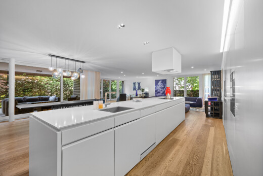 kitchen featuring open floor plan, modern cabinets, a kitchen island with sink, white cabinets, and healthy amount of natural light