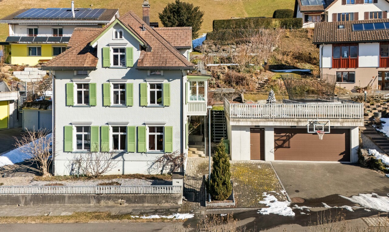 façade avec garage, allée, escaliers, balcon, et cheminée