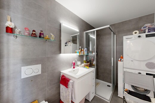 salle de bains avec tile wall, mur en carrelage, douche, lavabo (ou coiffeuse selon le contexte), et salle de bain complète
