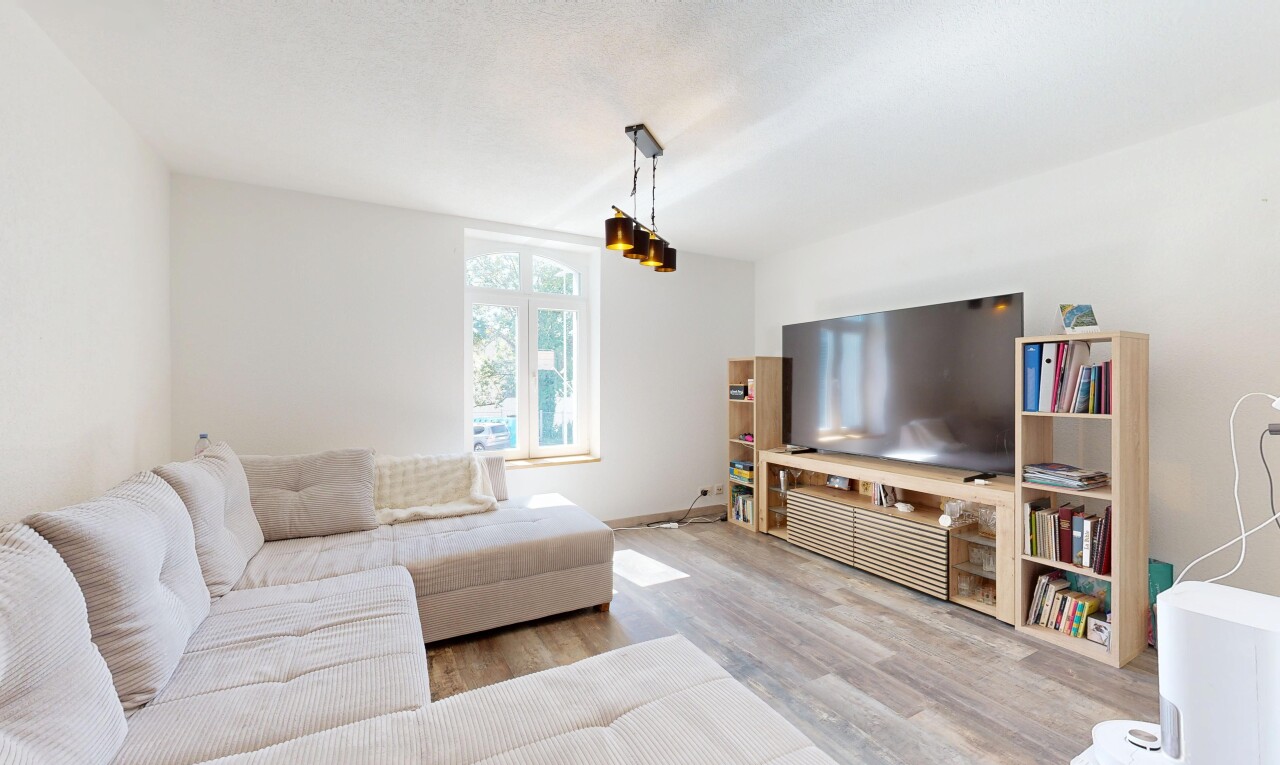 wohnzimmer mit fernseher, gipskartonwand, drywall, holzfußboden, und wood finish floor