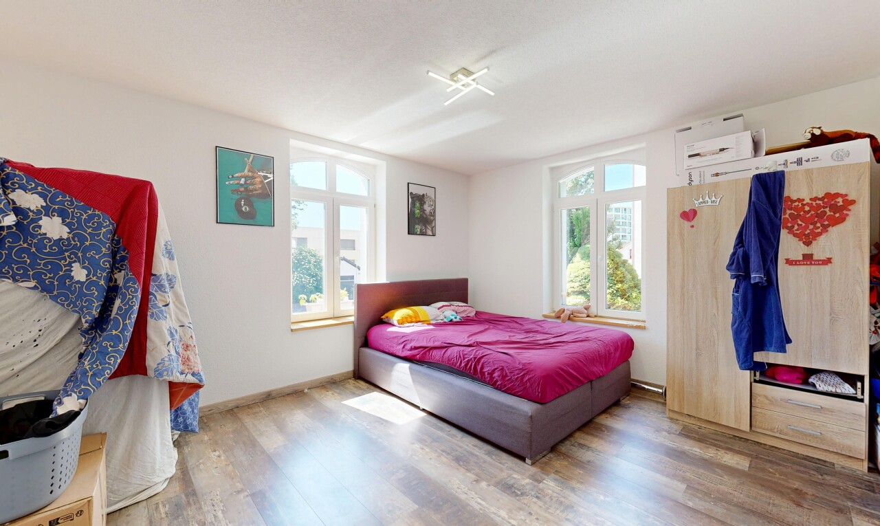 zimmer / schlafzimmer mit holzfußboden, wood finish floor, gipskartonwand, drywall, und natürliches licht