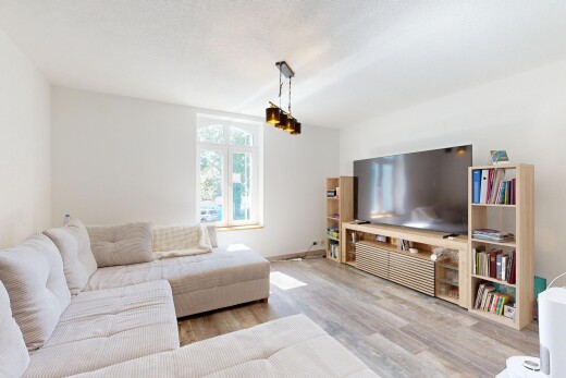 wohnzimmer mit fernseher, gipskartonwand, drywall, holzfußboden, und wood finish floor