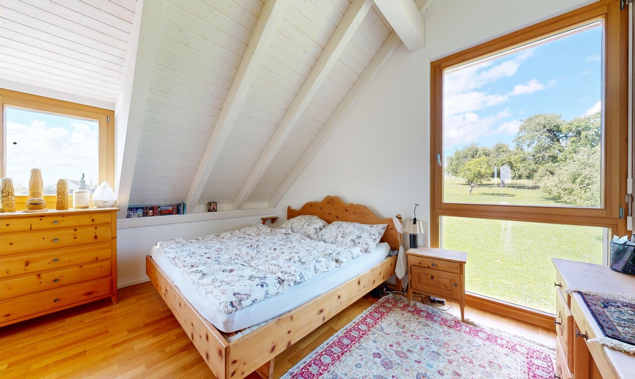 zimmer / schlafzimmer mit day time, balkendecke, beamed ceiling, holzfußboden, und wood finish floor