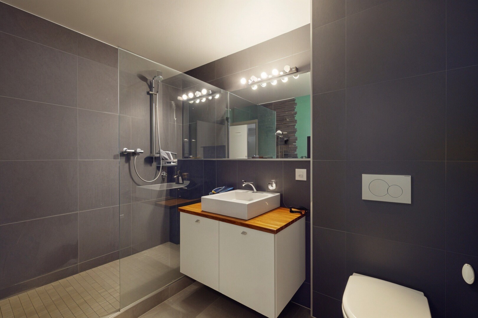 bathroom featuring tile walls, a walk in shower, and vanity