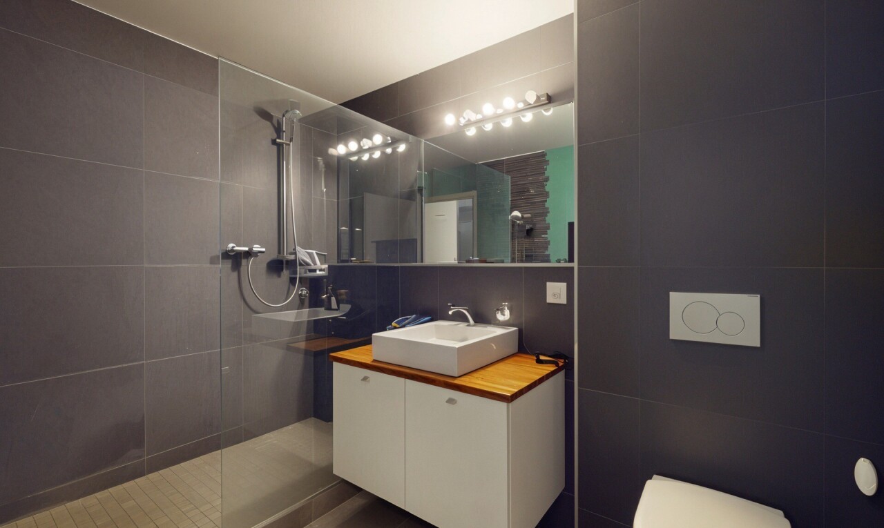 bathroom featuring tile walls, a walk in shower, and vanity