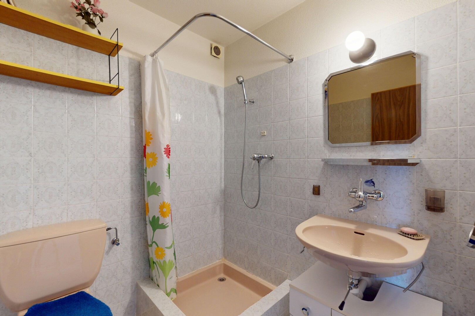 bathroom featuring a sink, tile walls, tiled shower, and toilet