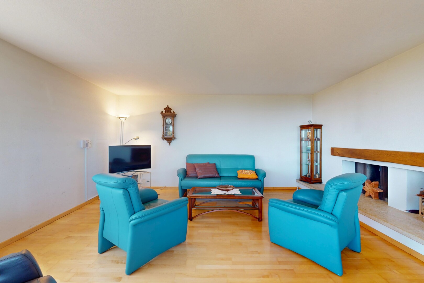 living area with baseboards, a multi sided fireplace, and wood finished floors
