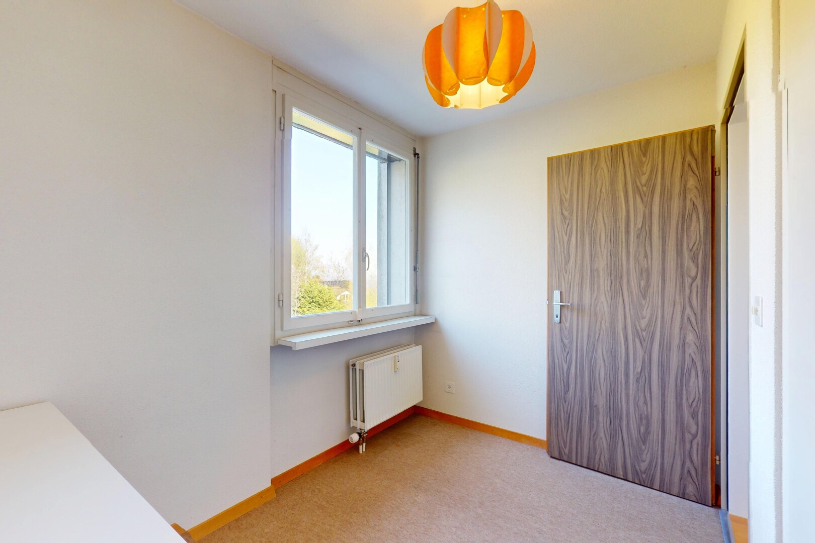 unfurnished room featuring radiator, light colored carpet, and baseboards