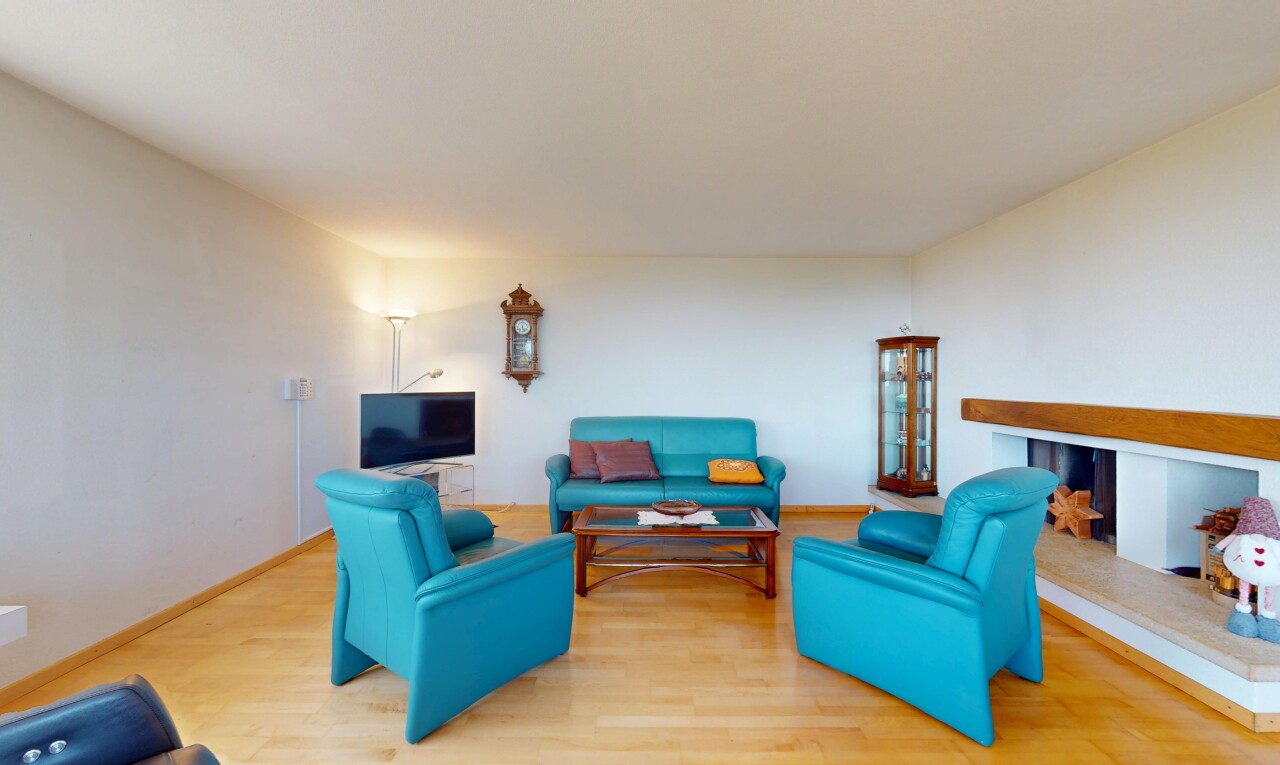 living area with baseboards, a multi sided fireplace, and wood finished floors
