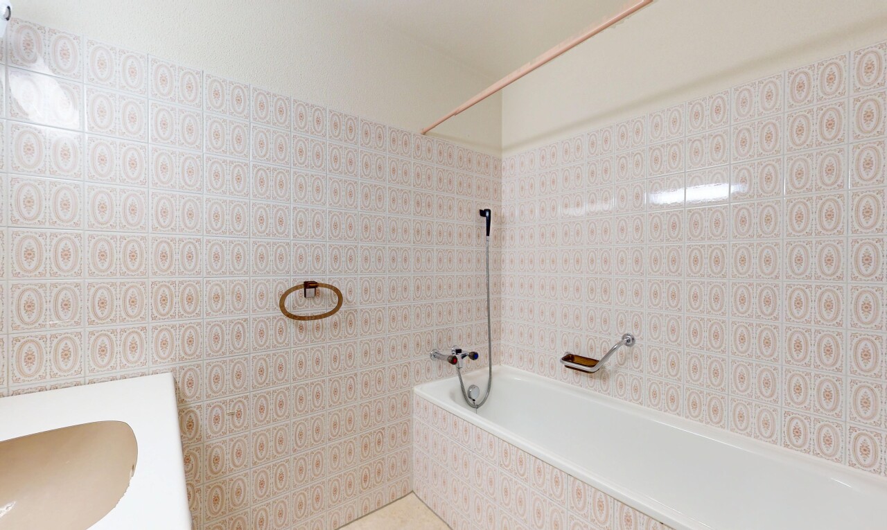 bathroom featuring a sink, tile walls, tiled shower, and a relaxing tiled tub