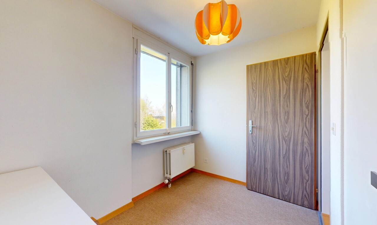 unfurnished room featuring radiator, light colored carpet, and baseboards
