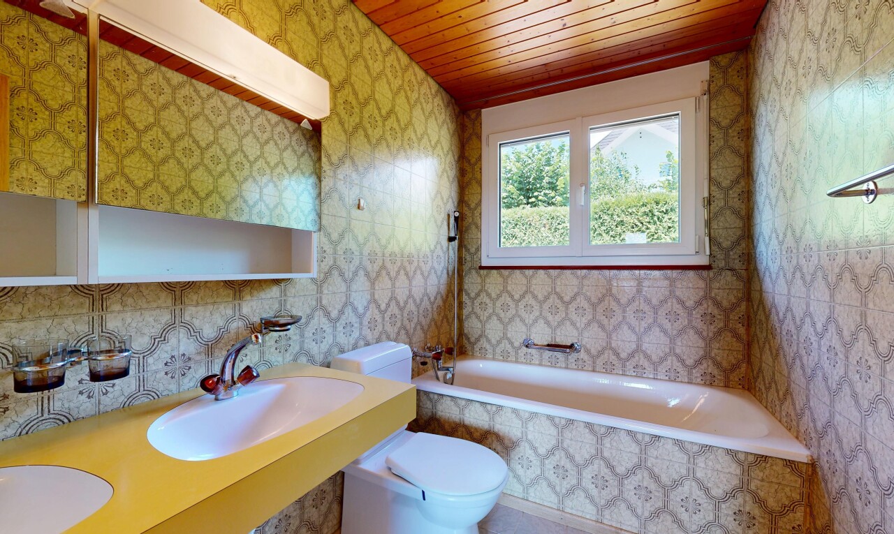 bathroom featuring wallpapered walls, tiled shower / bath, and wood ceiling