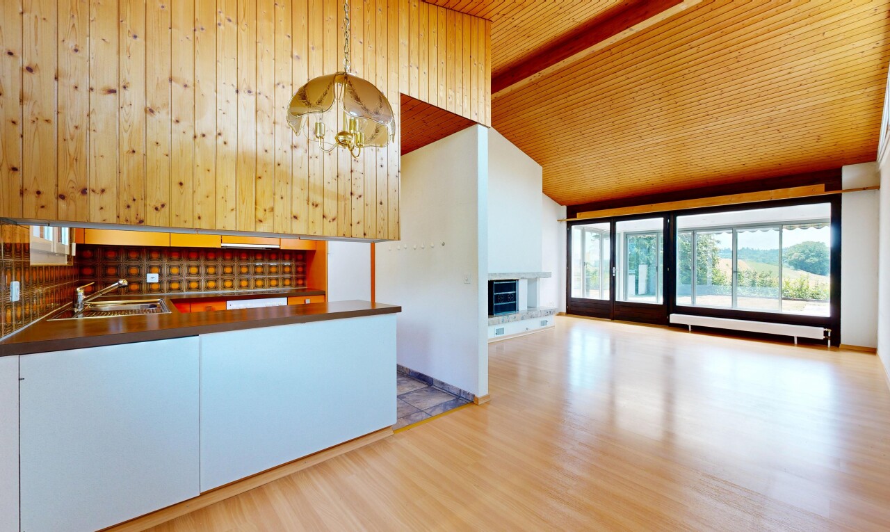 kitchen with a fireplace with raised hearth, light wood-style flooring, a chandelier, open floor plan, and a vaulted wooden ceiling