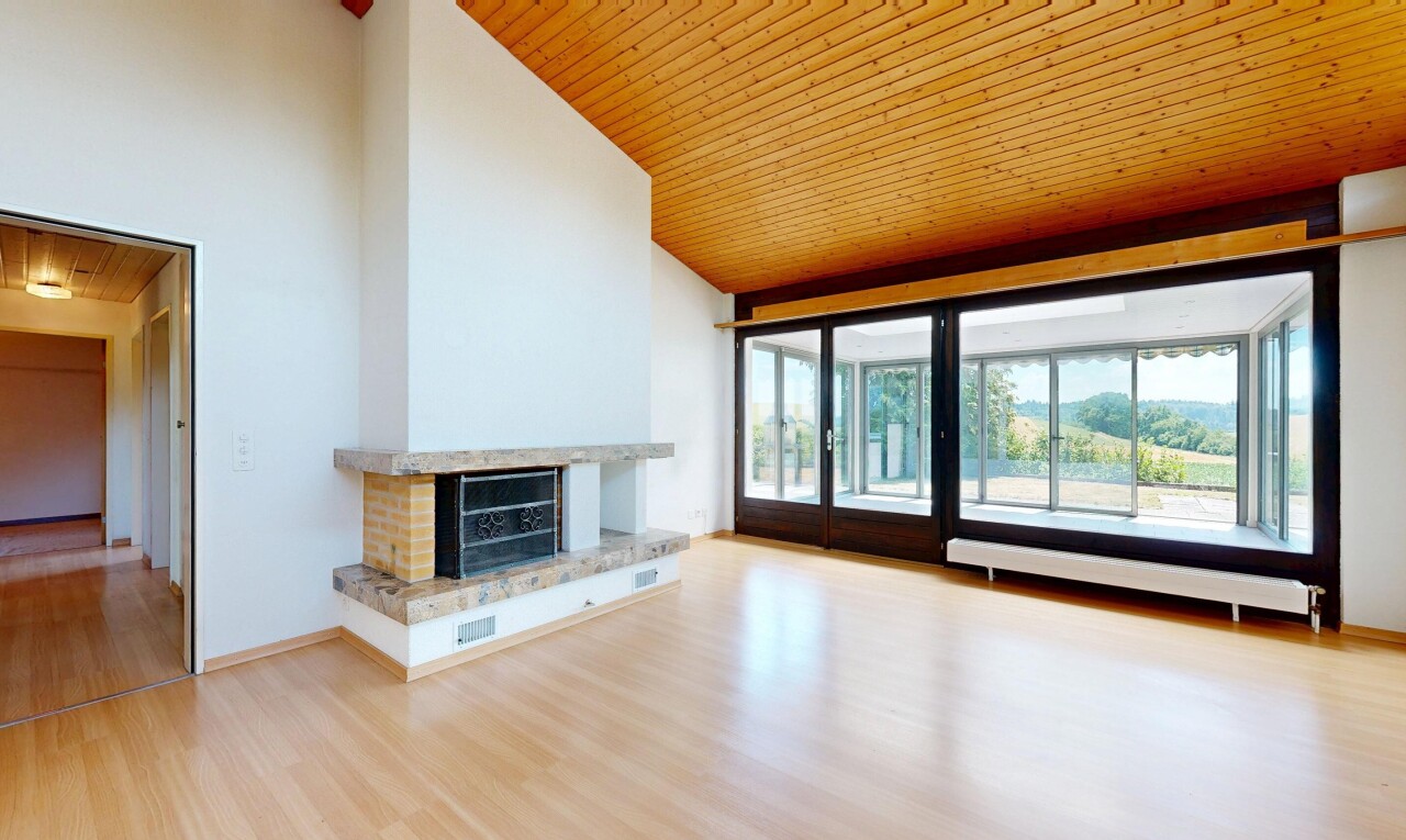 unfurnished room featuring a vaulted wooden ceiling, a fireplace with raised hearth, and light wood-style floors
