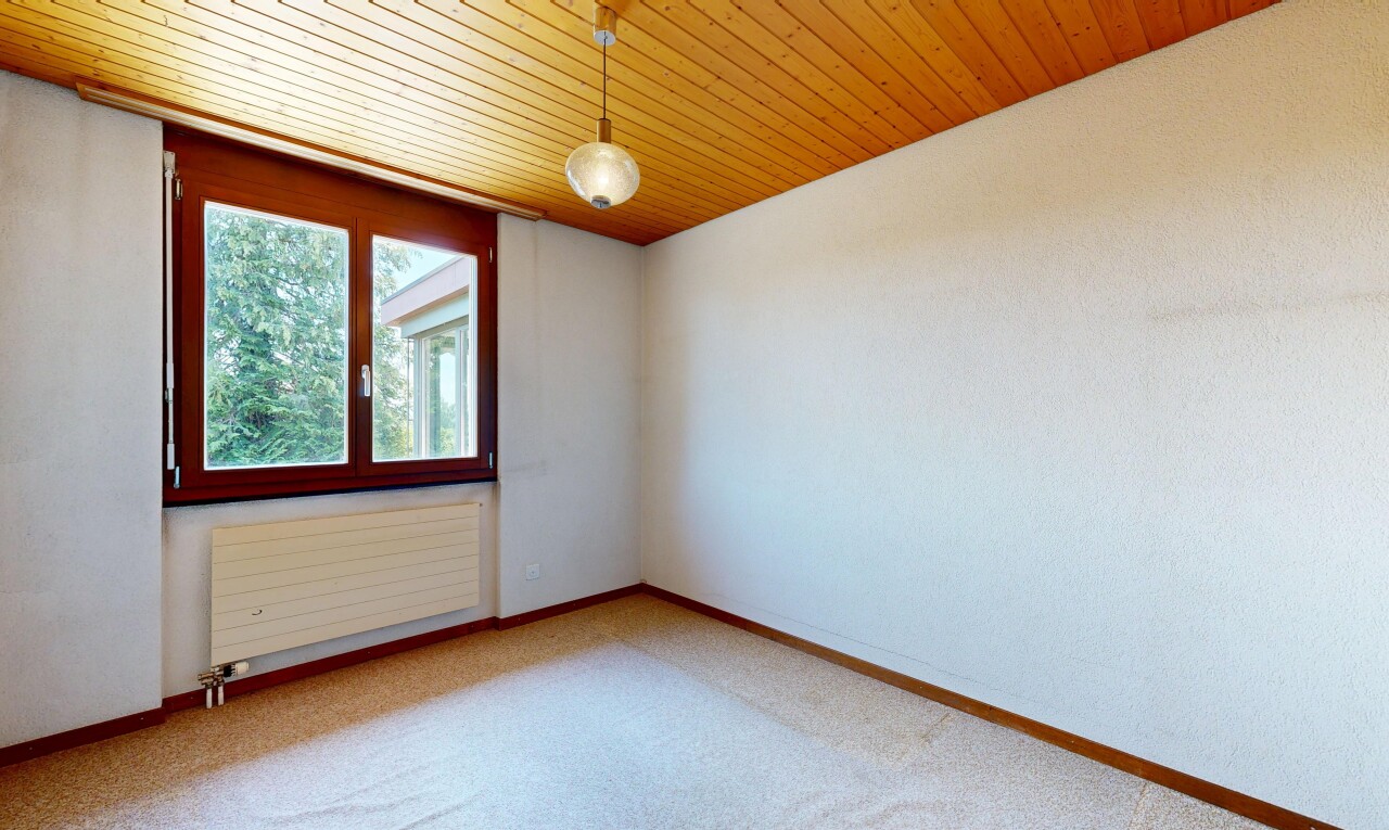 carpeted empty room with radiator heating unit and wood ceiling