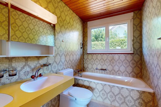 bathroom featuring wallpapered walls, tiled shower / bath, and wood ceiling