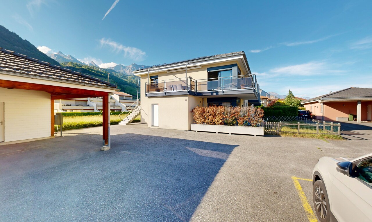 façade avec day time, escaliers, bardage en stuc, parking, et property visible