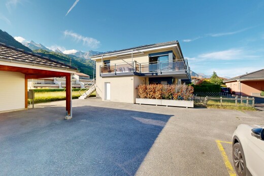 façade avec day time, escaliers, bardage en stuc, parking, et property visible