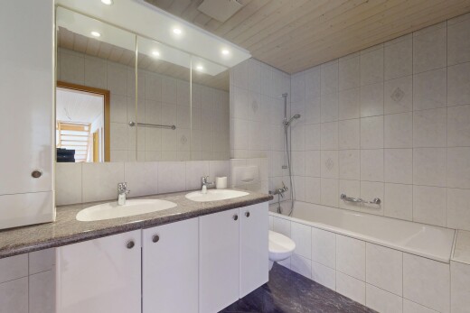 salle de bains avec évier, tile tub, mur en carrelage, tile wall, et douche-bain combinés