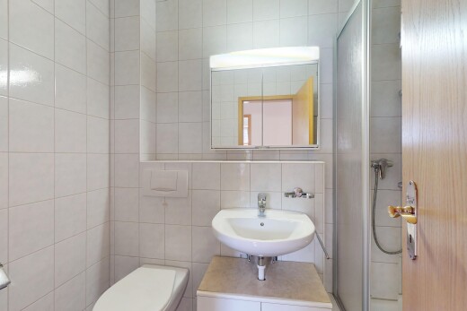 salle de bains avec évier, mur en carrelage, tile wall, toilette, et douche