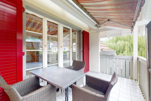 terrasse avec auvent, coin repas extérieur, et portes-fenêtres