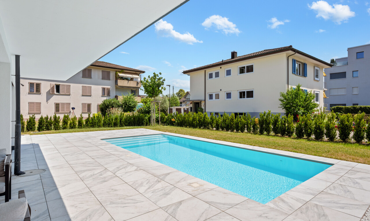 outdoor pool with a patio and a yard