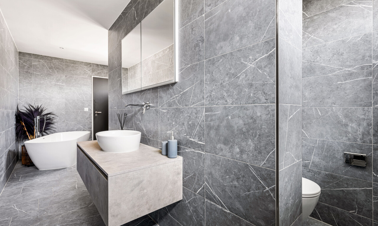 bathroom with tile walls, vanity, a soaking tub, and marble finish floors