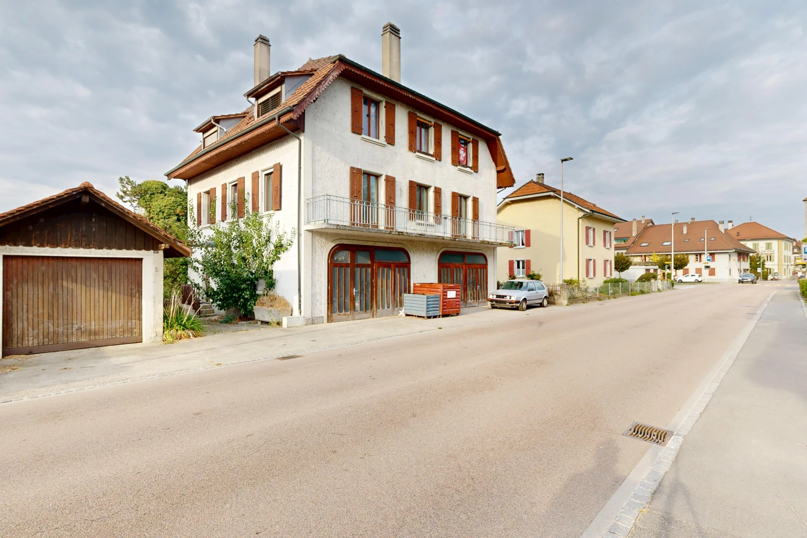 view of property with a chimney, an outdoor structure, and street lighting