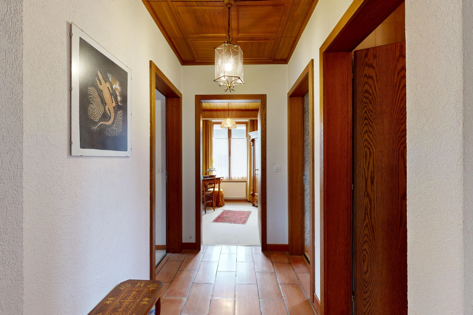 hall with wood ceiling, hanging light fixtures, and a textured wall