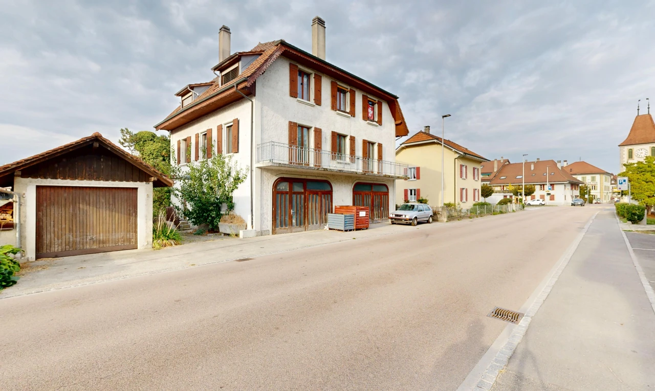 view of property with a chimney, an outdoor structure, and street lighting