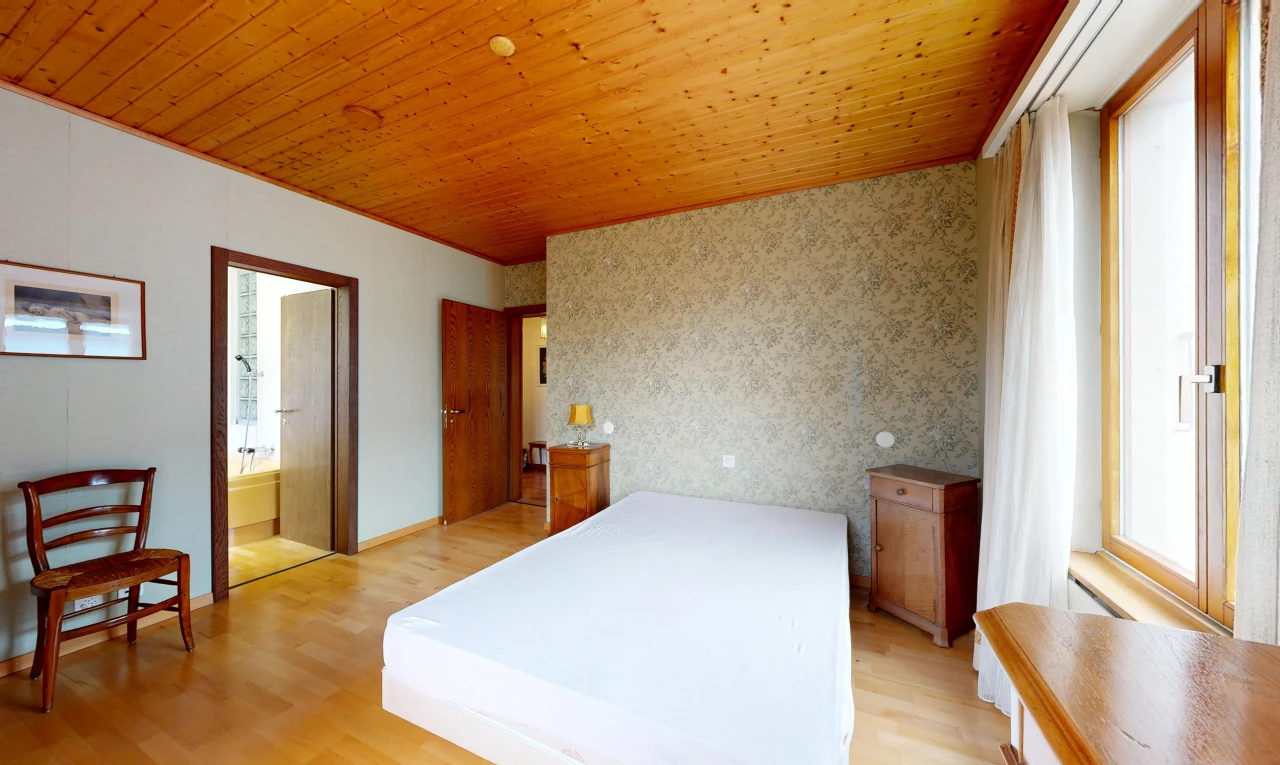 room featuring wood ceiling, light wood-style floors, wallpapered walls, ensuite bathroom, and an accent wall