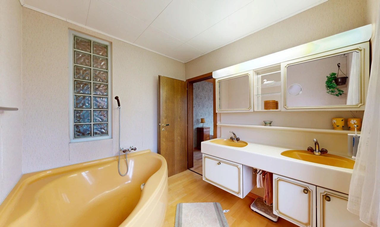 full bathroom with a bath, double vanity, and light wood-type flooring