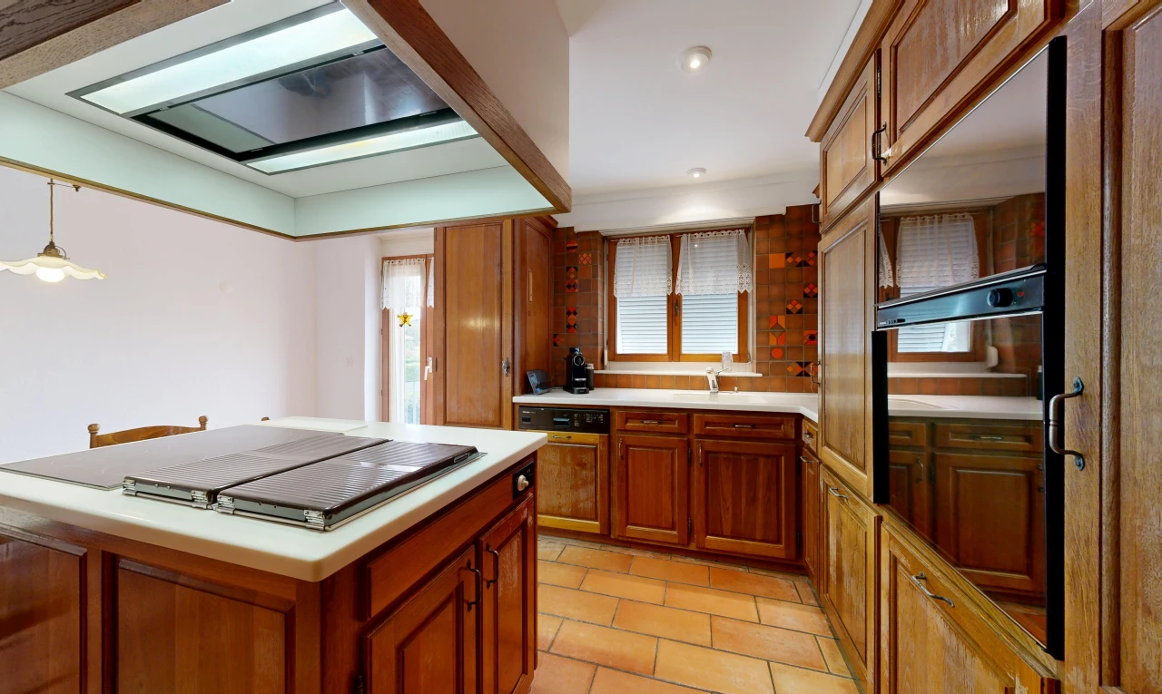 kitchen featuring ventilation hood, wood finish cabinetry, light countertops, recessed lighting, and black oven