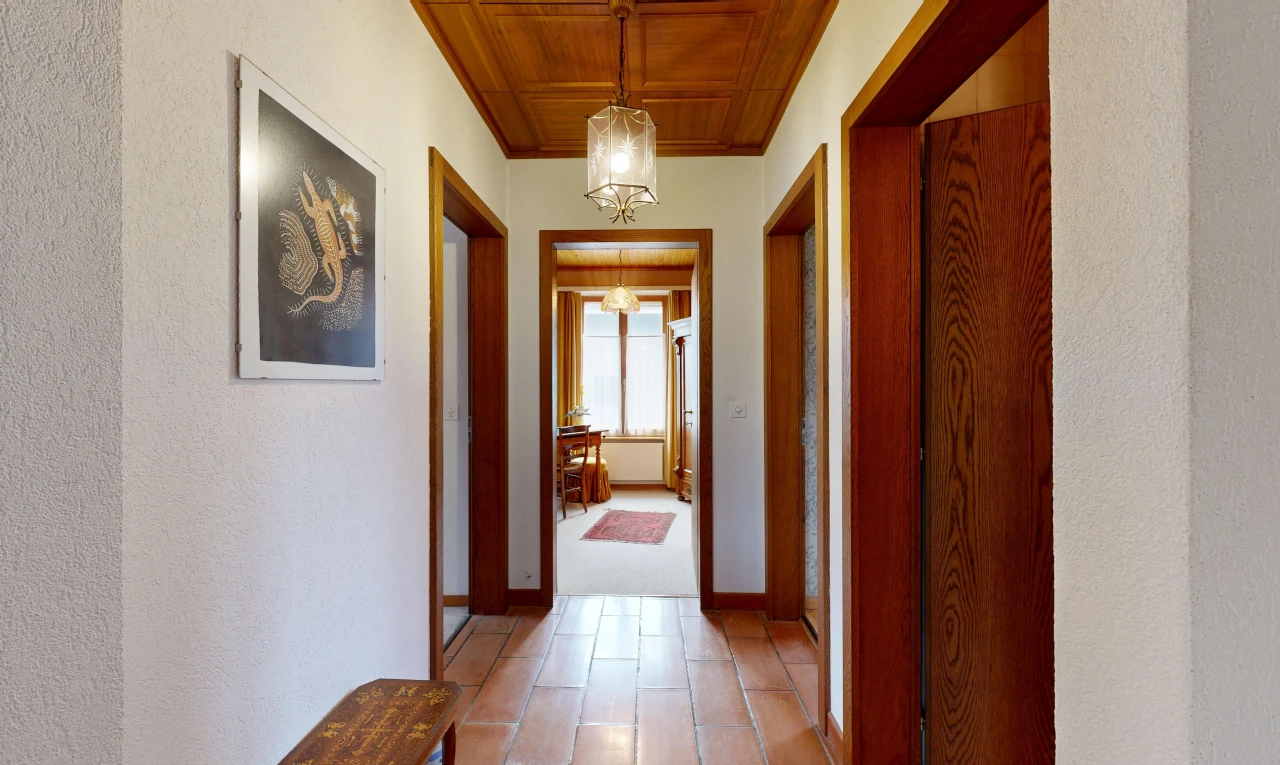 hall with wood ceiling, hanging light fixtures, and a textured wall