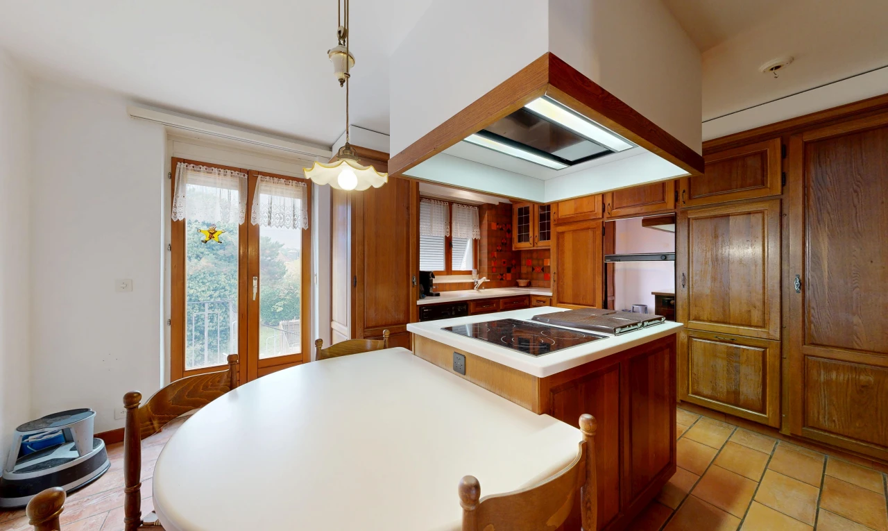 kitchen with island range hood, light countertops, wood finish cabinets, glass insert cabinets, and access to outside