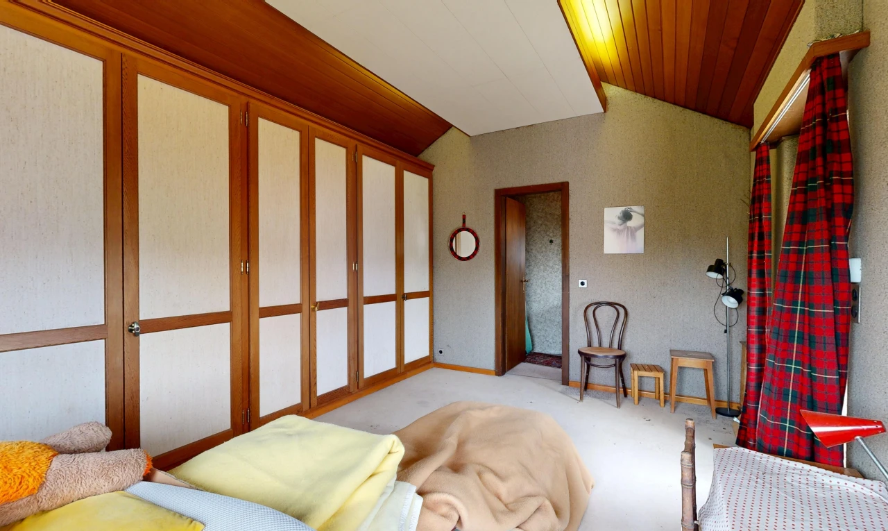 living area featuring vaulted ceiling and baseboards