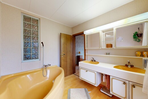 full bathroom with a bath, double vanity, and light wood-type flooring