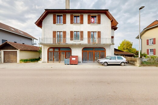 view of property featuring street lights, a chimney, a balcony, and stucco siding