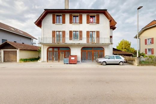 view of property featuring street lights, a chimney, a balcony, and stucco siding