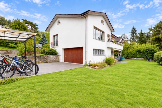 außenansicht mit eingebaute garage, rasen, auffahrt, stuckverkleidung, und property visible